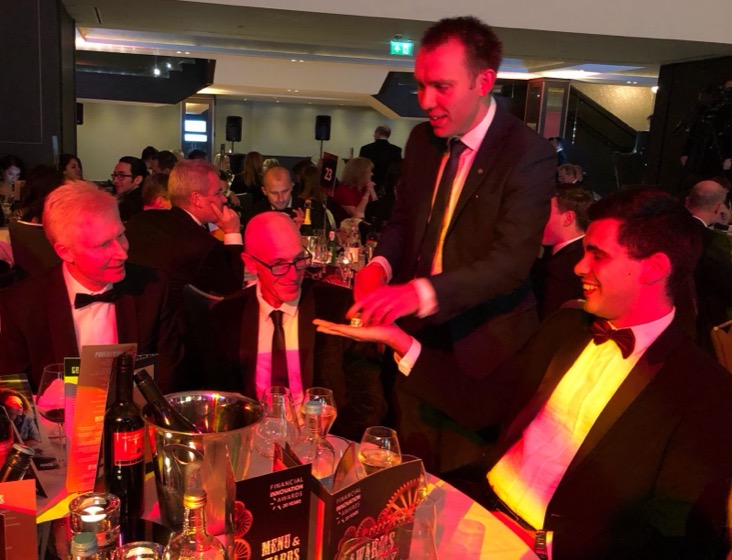 Dice appearing on a guest's palm at an awards dinner