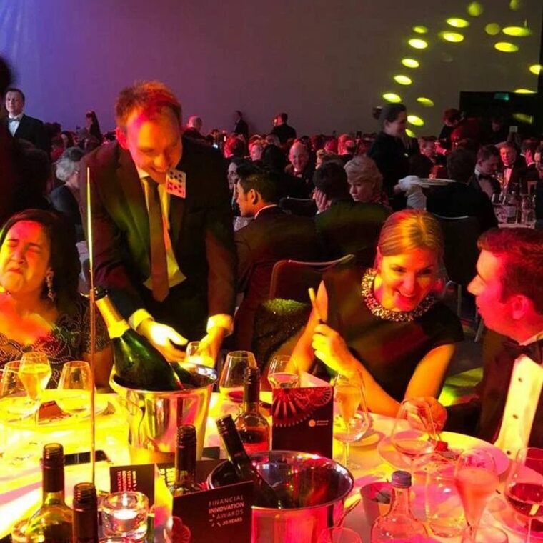 Neil performing between tables at a black tie awards dinner